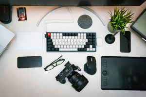 Modern graphic designer workspace with computer displaying colorful design software, drawing tablet, and creative tools