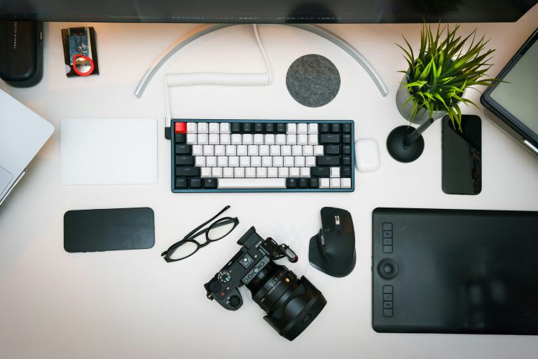 Modern graphic designer workspace with computer displaying colorful design software, drawing tablet, and creative tools