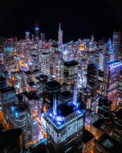 Aerial view of a modern smart city connected through digital IoT networks and data visualization.