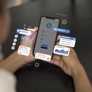 Person holding smartphone with floating 3D app interface elements including charts, profile icons, user forms, and settings.